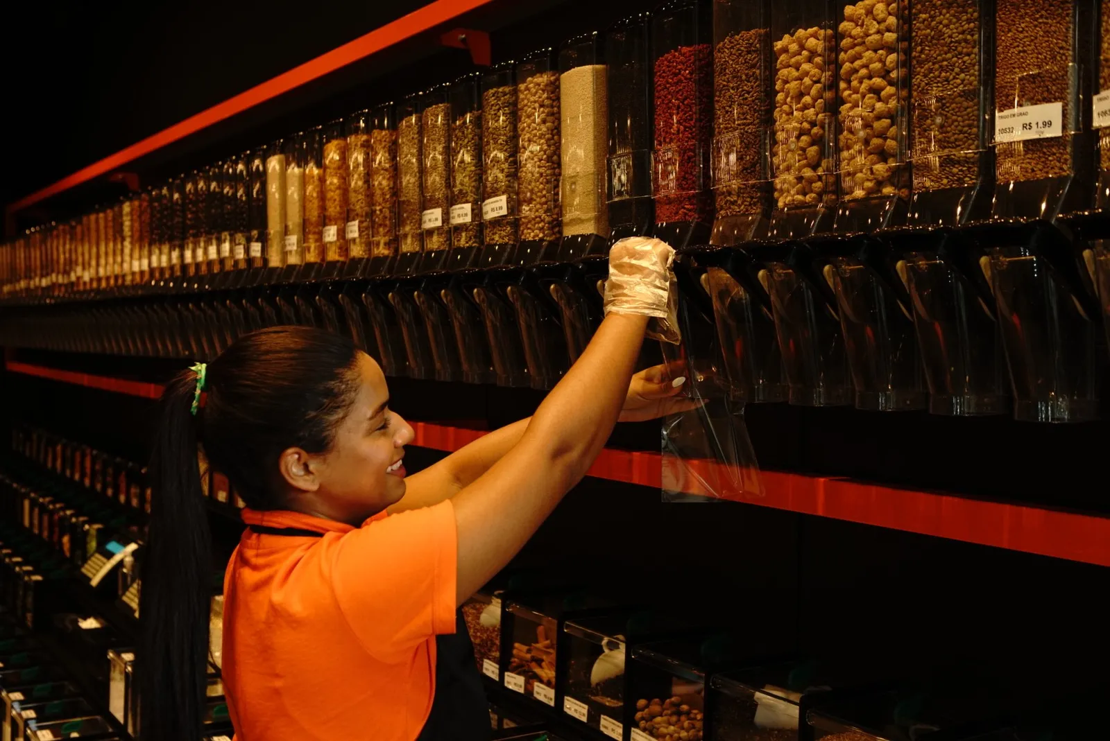 Consultora cuidando dos dispensers de granel da Cerealli